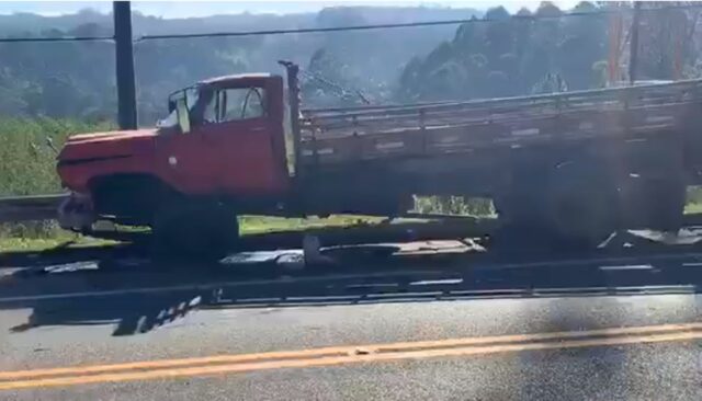 A imagem mostra o caminhão. Ele é vermelho e perdeu a roda superior direita no acidente. 