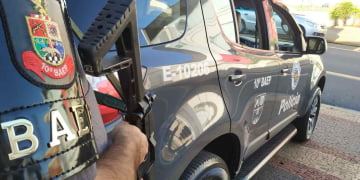 Na imagem temos um policial do BAEP armado ao lado da viatura E-10206