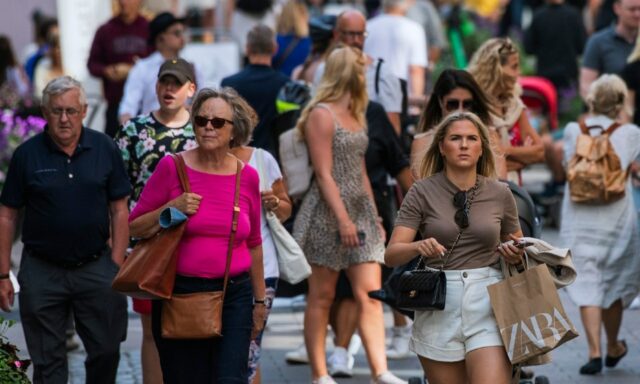 Uma foto que mostra pessoas andando na rua