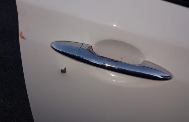 Uma foto do carro com sangue e marcas de tiro