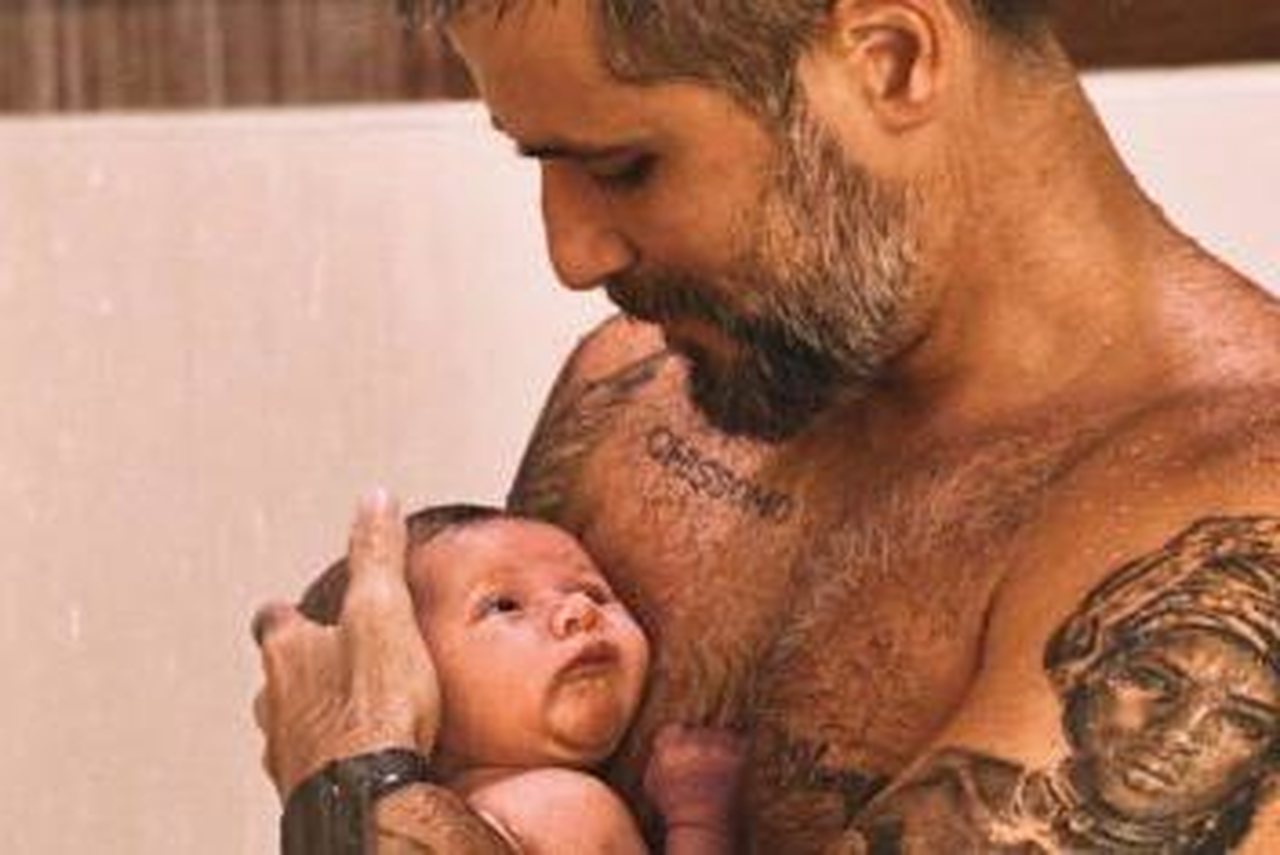 uma foto do Bruno Gagliasso com seu filho Zyan no colo