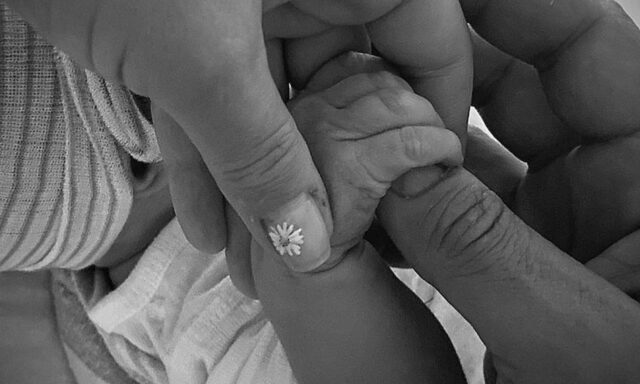 uma foto mão da pequena Daisy segurando as mãos de Katy e Bloom