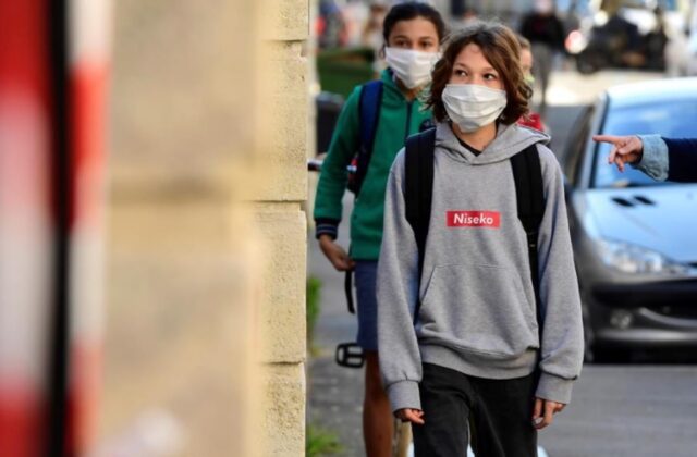 Uma foto dos estudantes indo à escola de máscara