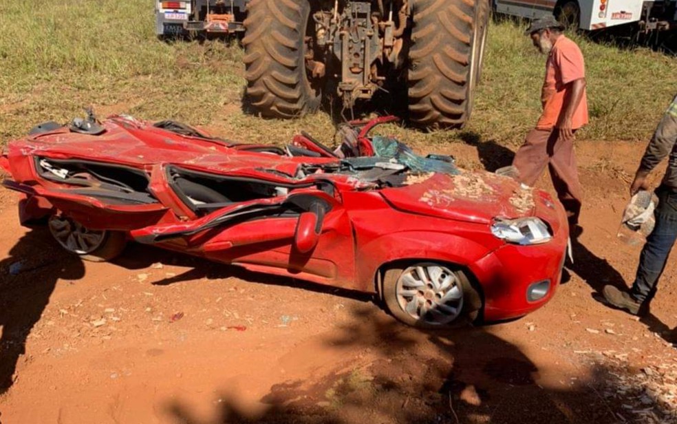 Caminhão com 30 toneladas de madeira tomba sobre carro de família