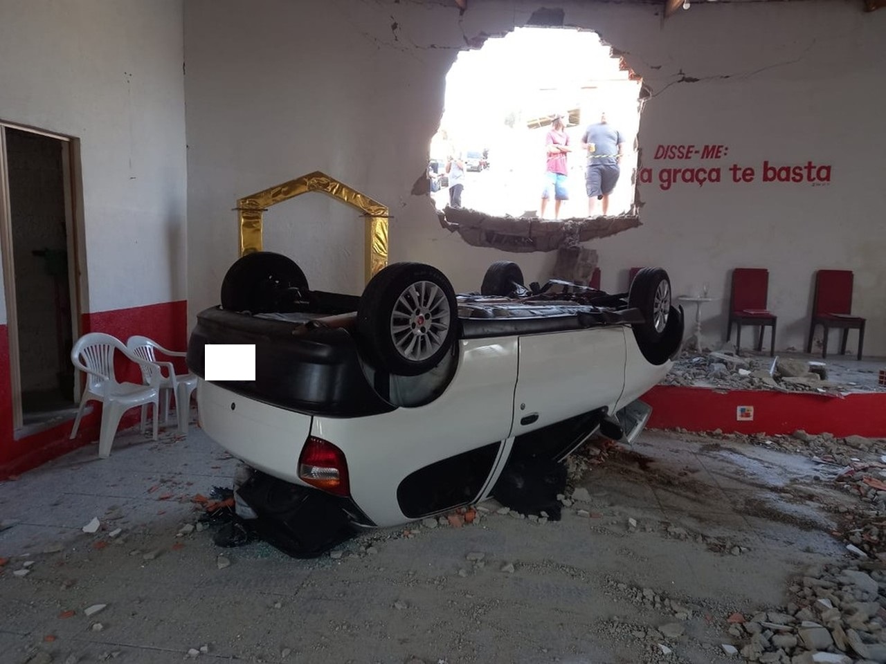 Mulher perde controle de carro, abre buraco em parede e capota dentro de igreja