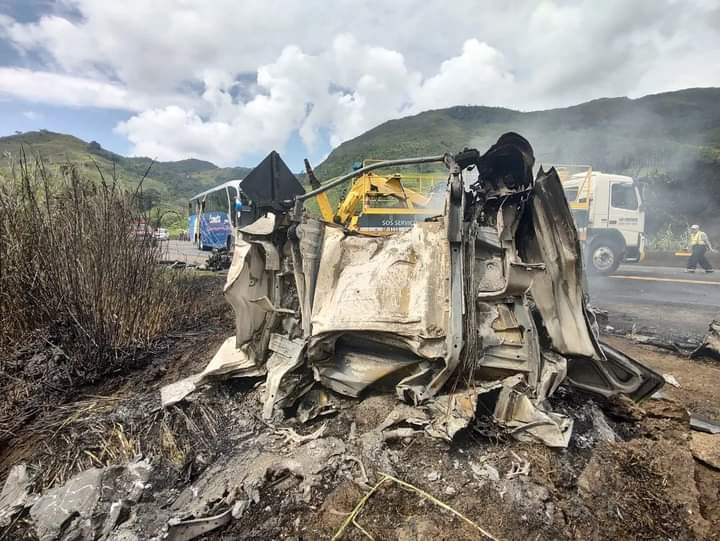 Motorista morre após caminhão bater em ônibus, cair em ribanceira e explodir