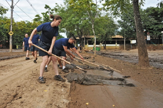 Alunos da Guarda Civil limpam lama da rua do Porto, em Piracicaba